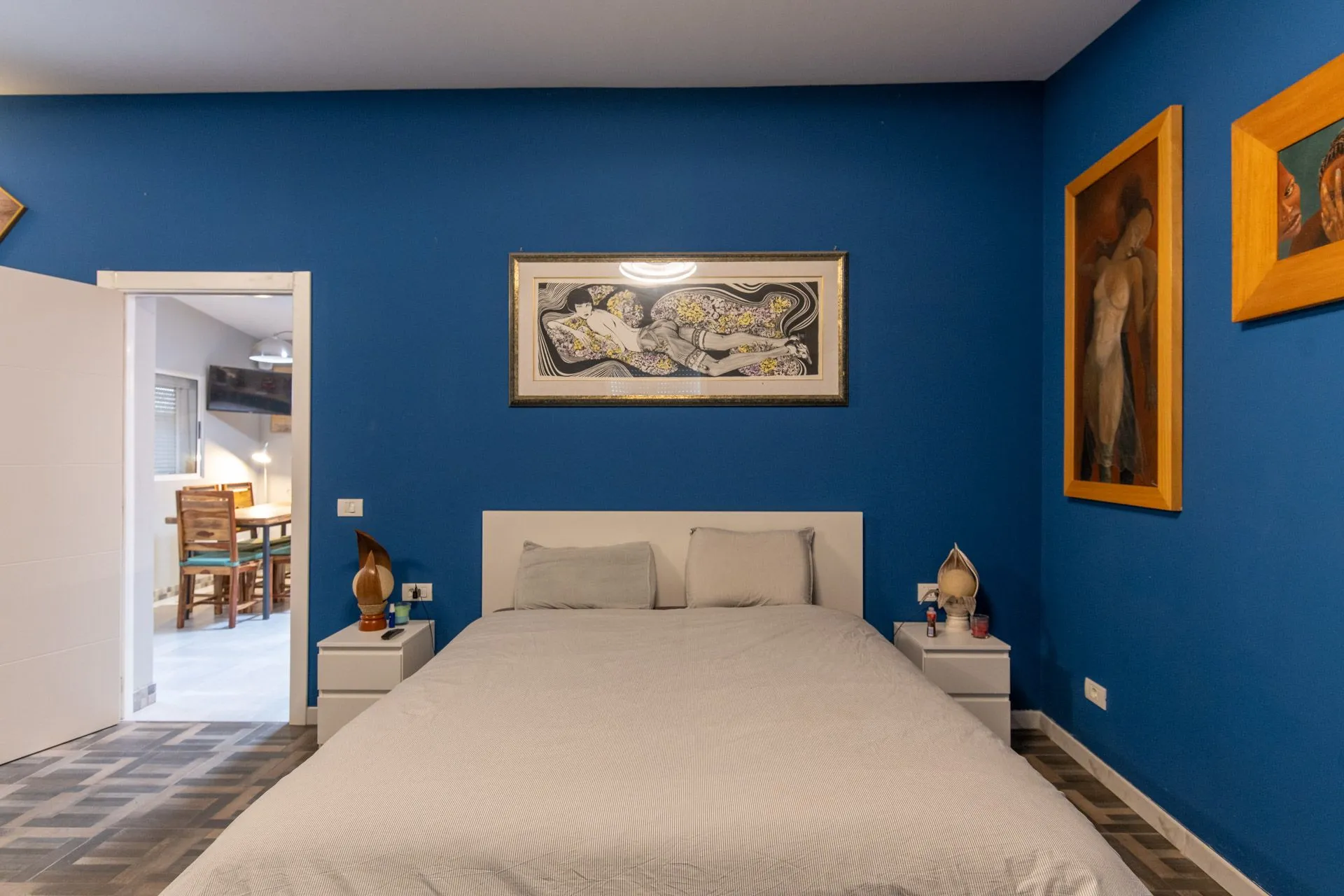Camera della Suite Mozart con pareti blu e quadri incorniciati appesi sopra il letto