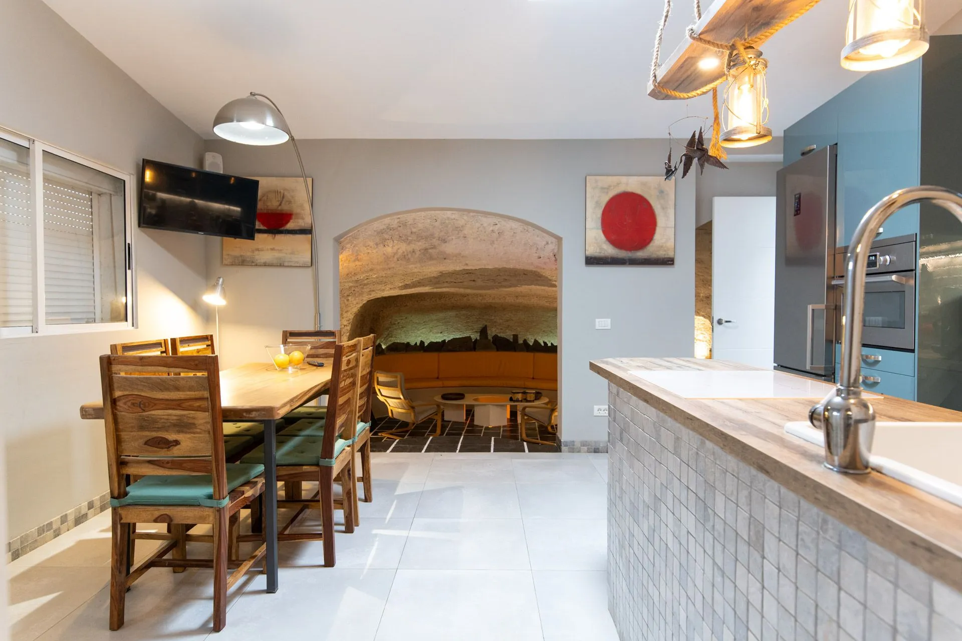 Cucina e sala da pranzo con vista su un salotto ricavato in una grotta