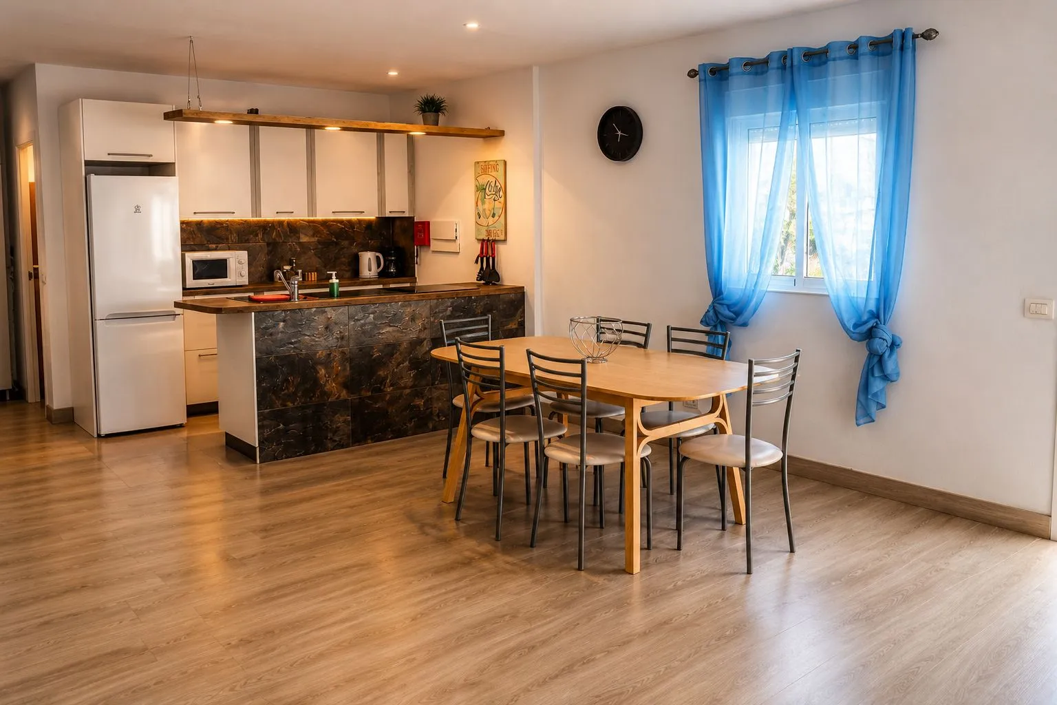 Cucina e sala da pranzo open space con tavolo in legno e tenda blu
