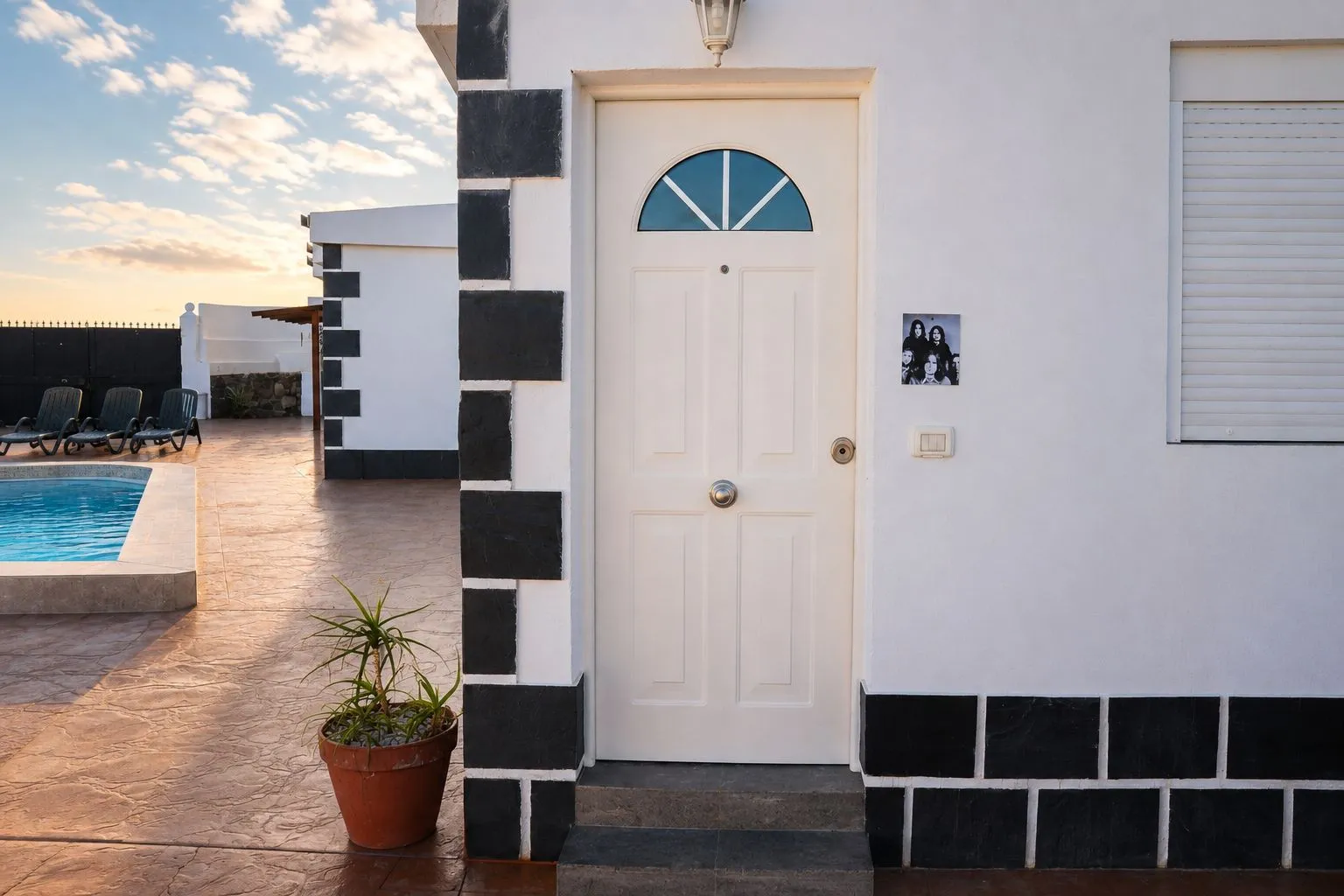 Ingresso di Casa Genesis con porta bianca e piscina visibile sullo sfondo