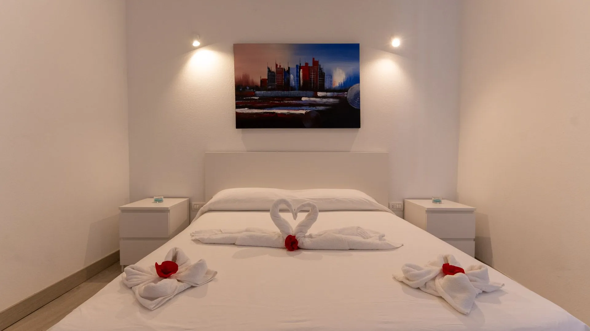 Letto matrimoniale in Casa Genesis con asciugamani piegati a forma di cuore e cigni