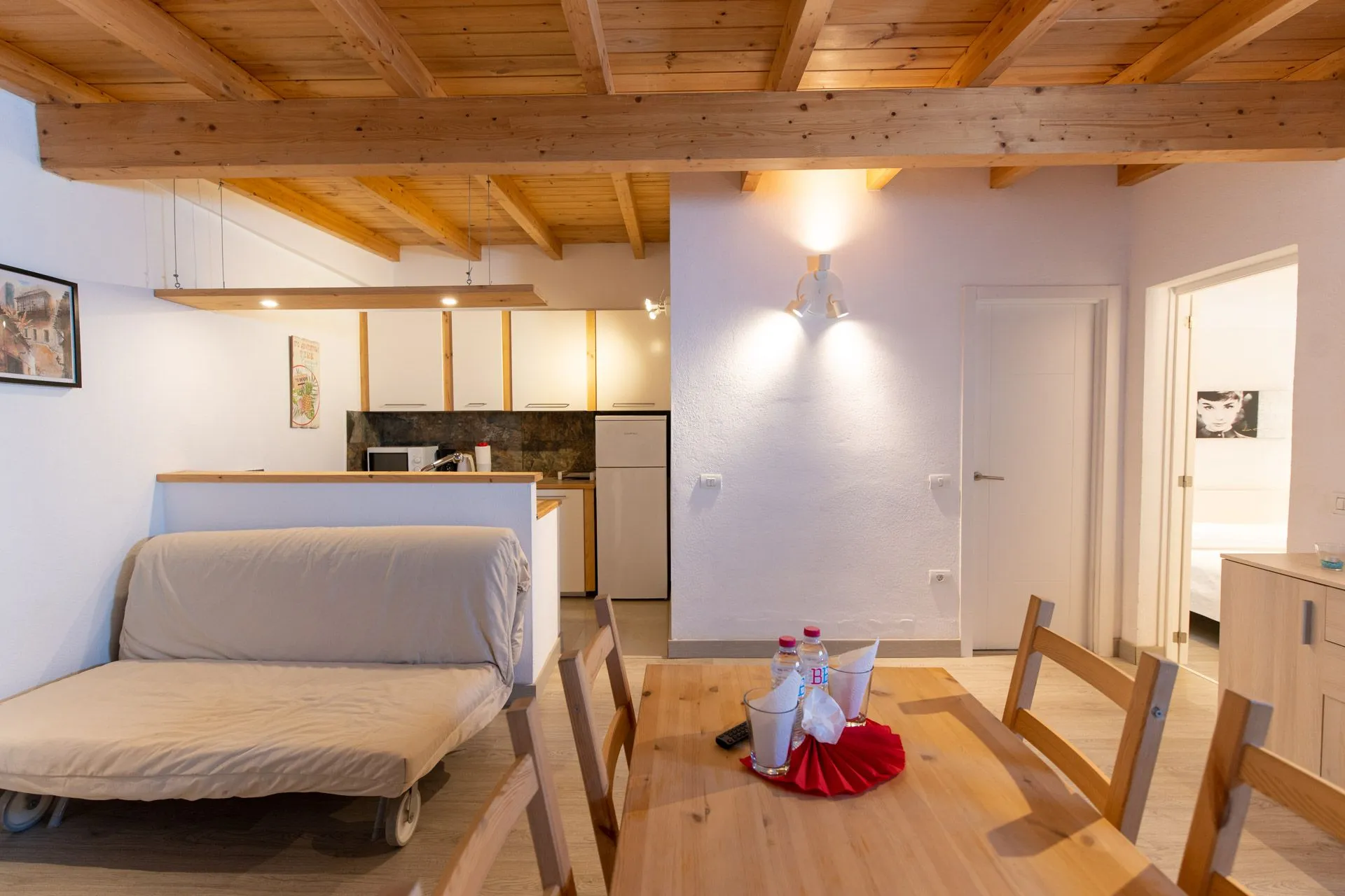 Soggiorno con divano letto, tavolo da pranzo in legno e cucina open space a Casa Wonder